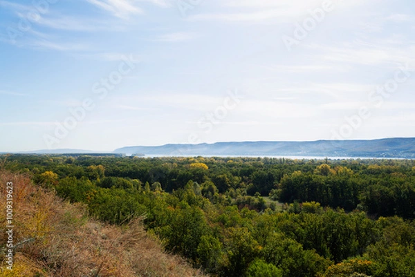 Obraz autumn landscape in the mountains. Autumn landscape with dense trees and vibrant foliage under a clear blue sky. from a bird's eye view. Scene of unspoiled nature.
