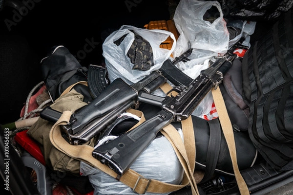 Fototapeta Arms trafficking. different rifles. clandestine sale of weapons. illegal deal to sell weapons. A man pulls an assault rifle out of a car. The concept of arms smuggling.