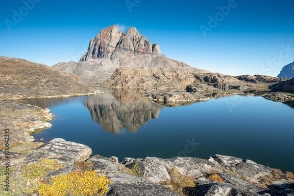 Fototapeta Mountains and lake in Uummannaq during summer time, Greenland. Located on an island. Beautiful arctic landscape. View of the Greenlandic island of Uummannaq with its distinctive rock.