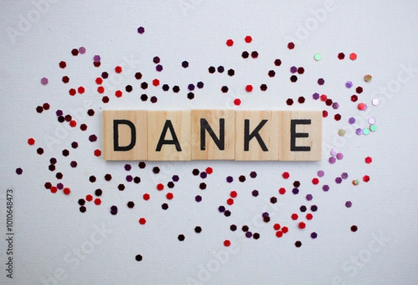 Obraz Thank you card with german language DANKE on wooden block on background with shiny glitters, panorama