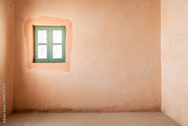Fototapeta A simple room with warm earth-toned walls and a green window letting in natural light