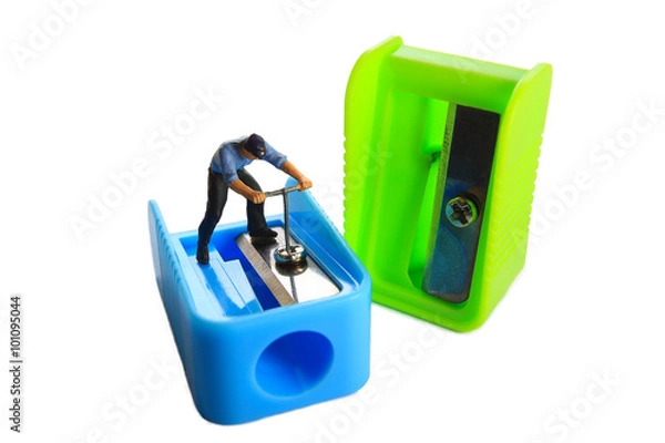 Fototapeta Little mechanic is tightening bolt of pencil sharpener.