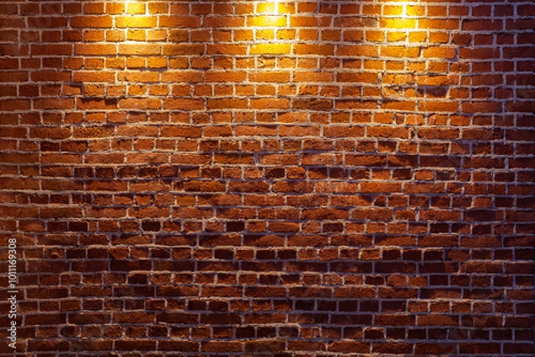 Fototapeta A beautiful old brick wall illuminated by three light sources from above.
