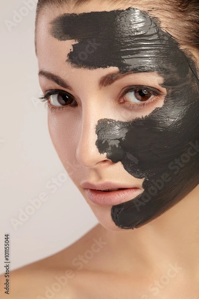 Fototapeta Beautiful girl with clay mask on her face