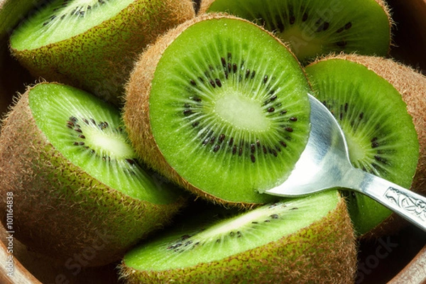 Obraz Soczysty dojrzały owoc kiwi w drewnianej misce z łyżką