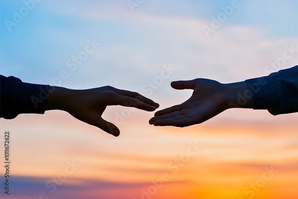 Fototapeta A touching encounter between two silhouettes of hands reaching toward each other, set against a vibrant and peaceful sunset sky, symbolizing connection and hope.
