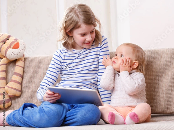 Obraz Two sisters watching tablet PC