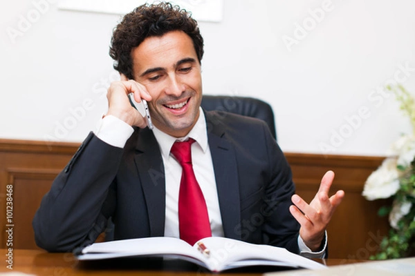 Obraz Cheerful man in office answering the phone
