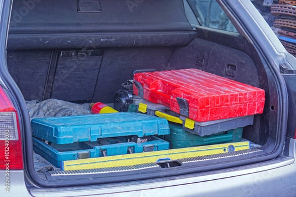Obraz Stack of work tool boxes in open car trunk