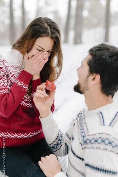 Obraz Handsome caucasian man doing a marriage proposal on bright winter day in the park for the valentines day
