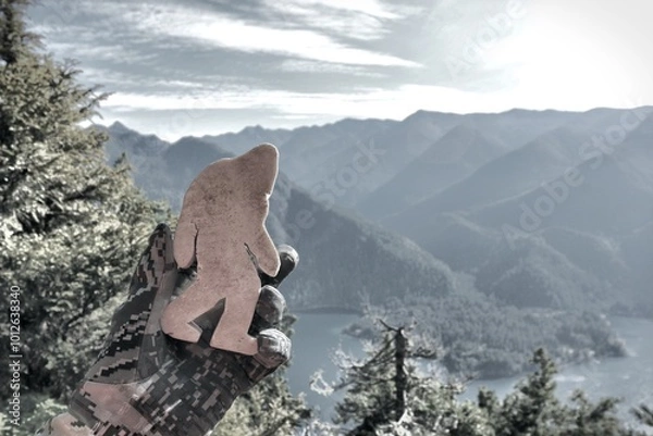 Fototapeta Stone Bigfoot looking out over mountain area scenery from above