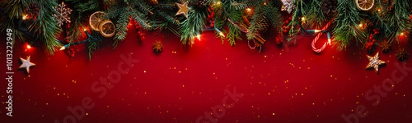 Fototapeta Christmas fir branches with gingerbread cookie on glittering red background with winter holiday lights