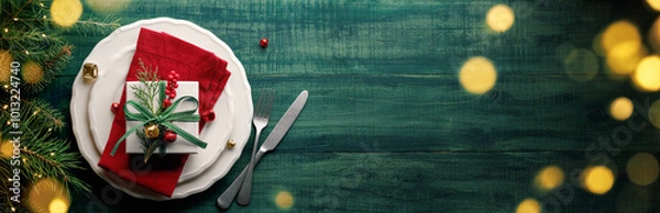 Fototapeta Christmas gift box on plate with cutlery and fir branches on wooden table.