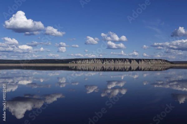 Fototapeta Reflection of clouds in the river and the distant shore. Lena river. Yakutia. Russia.