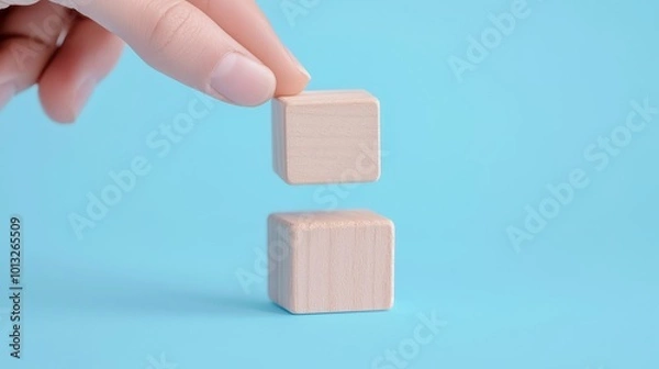 Fototapeta Wooden Block Symbols for Communication, a hand arranging wooden blocks representing telephone, email, and website, illustrating contact options in a marketing context