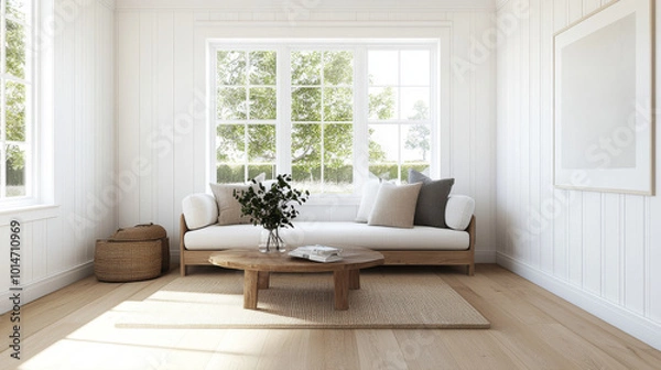 Fototapeta A bright and airy living room featuring modern sofa with cushions, round wooden coffee table, and cozy rug. Large windows allow natural light to fill space, enhancing serene atmosphere
