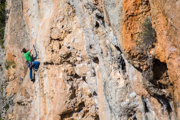 Obraz A rock climber ascends to the summit via a difficult route.