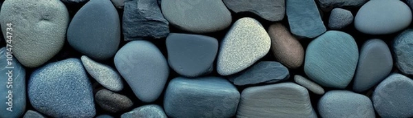 Fototapeta Smooth blue river stones in various shades, creating a textured pattern on a natural surface.