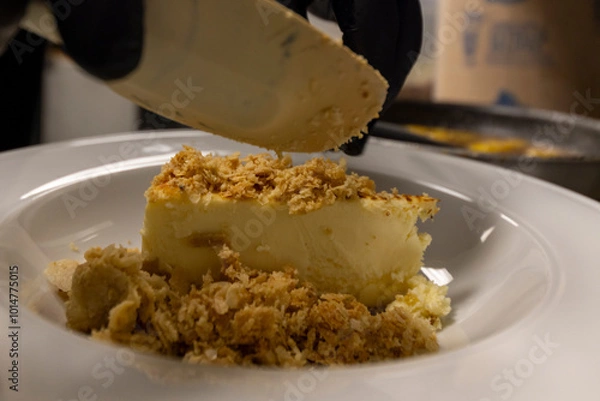 Fototapeta Cheese cake, bananas, caramel dessert. Making dessert behind the scenes. Vanilla Ice cream, whip cream topped on cheese cake, banana sauce topping with caramel on top. 