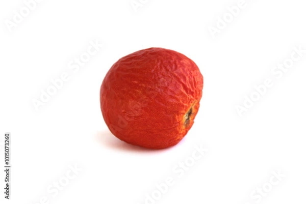 Obraz Spoiled product, wrinkled tomato lies on a white background.