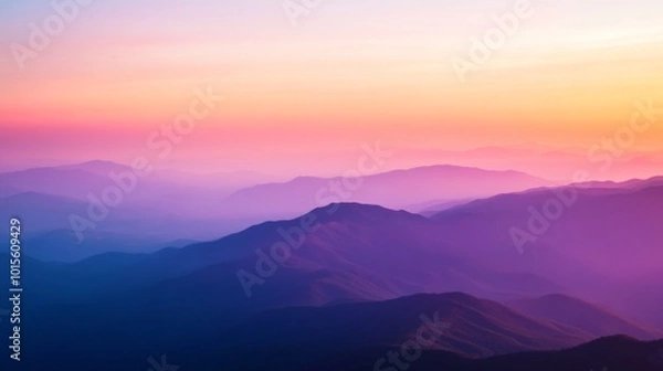 Fototapeta Witness a breathtaking mountain range enveloped in rich oranges and purples as the sun sets, casting shadows over the rugged peaks. The serene landscape invites reflection