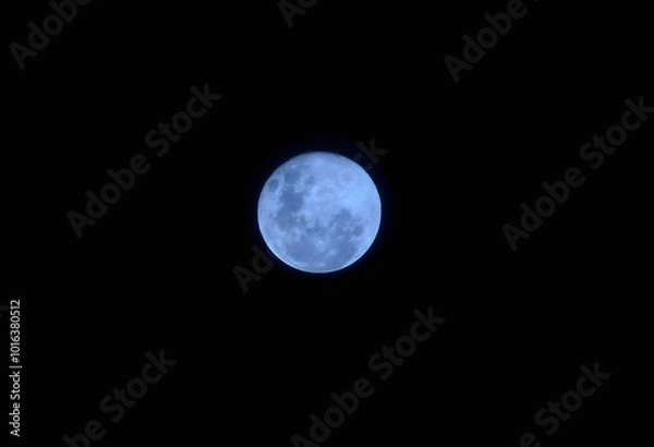 Fototapeta A closeup of a full blue moon against the dark emptiness of space