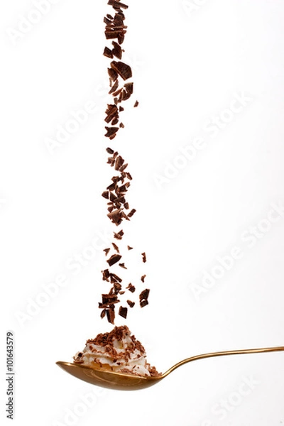 Obraz Chocolate glakes falling into a spoon with whipped cream