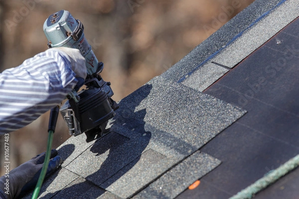 Obraz Attaching shingles to the roof.