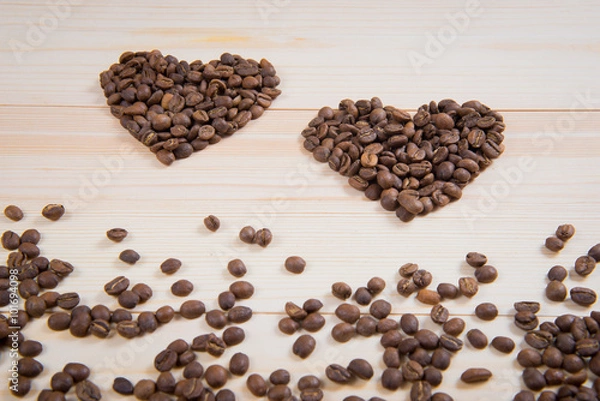 Fototapeta coffee in the shape of a heart on a wooden desk surface. coffee in the shape of a heart. Two hearts of coffee
