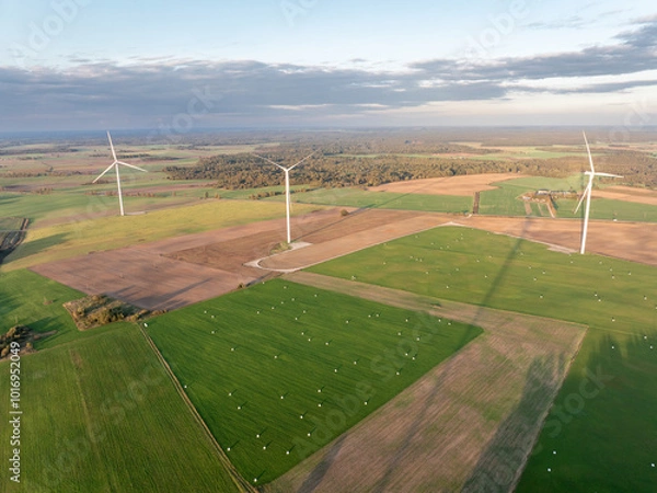 Fototapeta Wind Turbine Wind Park. Aerial Drone View. Aerial Drone Point of View, with more wind turbines in the distance. Sustainable synergy of onshore and farming. Beautiful Landscape. Golden Hour