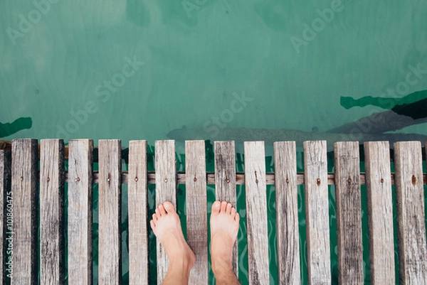 Fototapeta Man with bare fee on a wooden bridge,top view