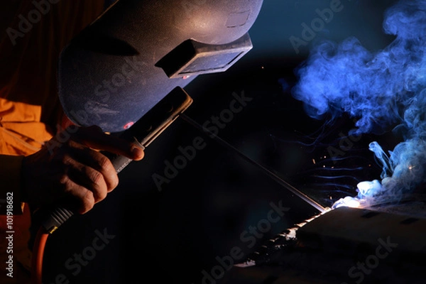 Fototapeta Close-up of welder working in workshop.