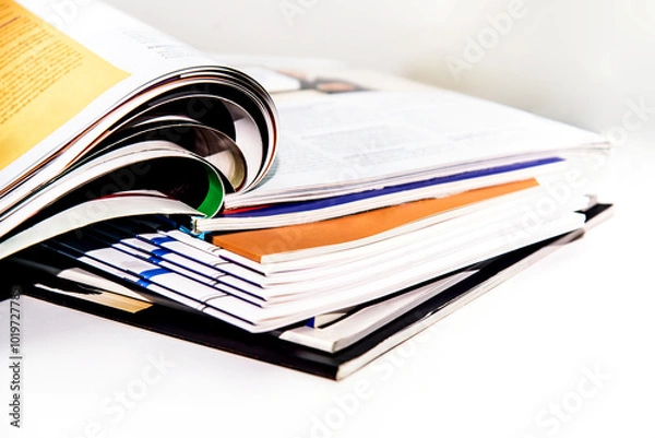 Fototapeta Stack of magazines on white background. Shallow depth of field.