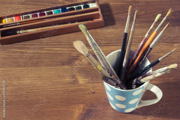 Fototapeta old paintbrushes in a mug or cup with watercolor or watercolour
