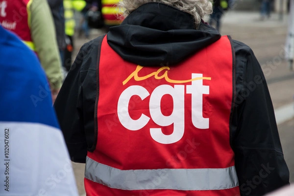 Obraz Mulhouse - France - 5 october 2024 - Portrait on back view of  people protesting in the street with a red CGT syndicate jacket