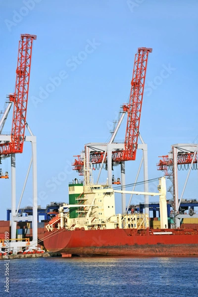 Fototapeta Container stack and ship under crane bridge