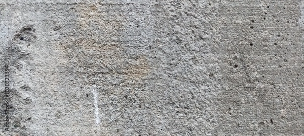 Fototapeta Rough Concrete Surface Texture Close-Up. A detailed close-up of a rough concrete surface, showcasing natural imperfections and a rugged texture, for industrial designs or as a grunge background