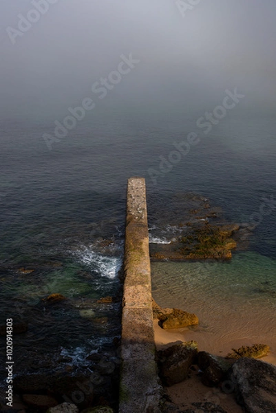 Obraz  A long, narrow pier stretching into the misty ocean. Perfect for projects related to travel, nature, or solitude.