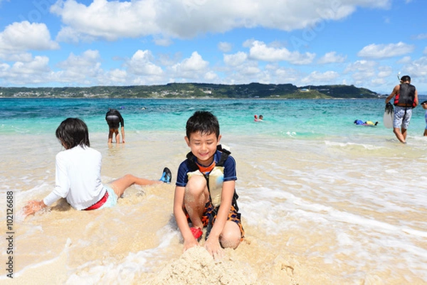 Obraz 海辺で寛ぐ笑顔の男の子