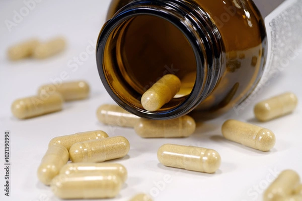 Obraz Overdose. Yellow capsules scattered on the table and open glass jar for capsules