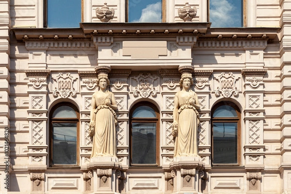 Fototapeta A fragment of the facade of an old mansion with columns in the form of female figures