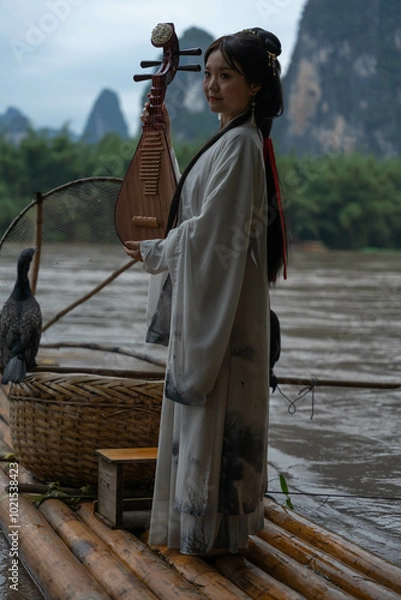 Obraz Young woman in Hanfu playing pipa on a Bamboo Raft. Xingping, China. Vertical shooting