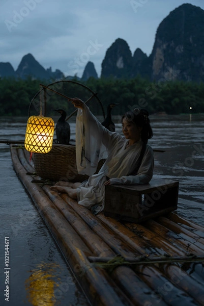 Obraz Hanfu Girl holding a lantern on a bamboo raft, Xingping, China. Vertical