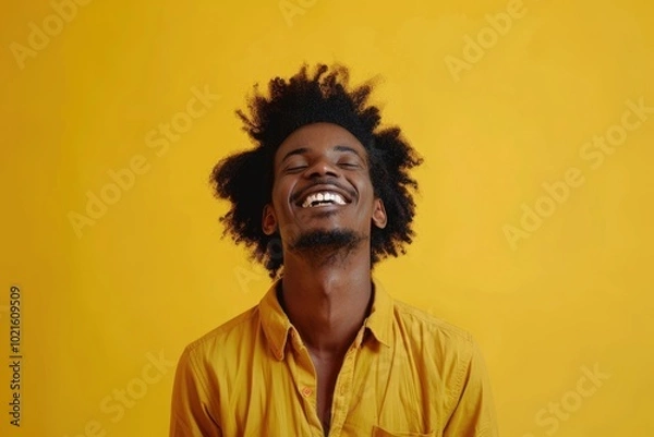 Fototapeta Happy smiling afro man posing on yellow studio background.