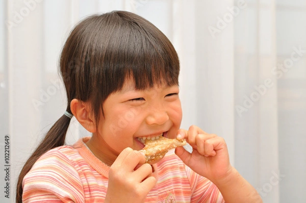 Fototapeta 手羽先を食べる女の子