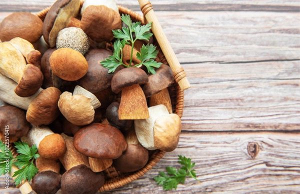 Fototapeta A vibrant assortment of fresh mushrooms and herbs in a woven basket on a rustic wooden table