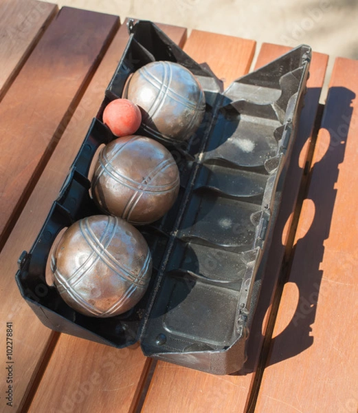 Obraz Metallic petanque balls and a small red jack on wood table
