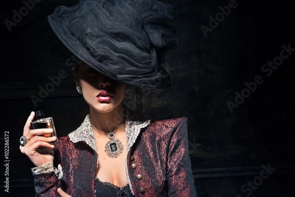 Obraz Dziewczyna w kapeluszu próbuje świeżych perfum