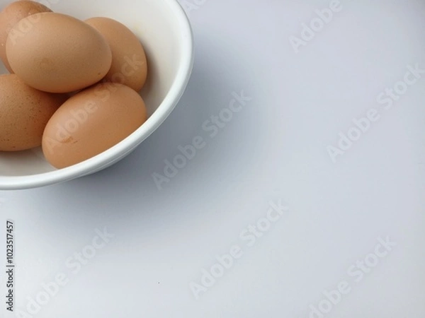 Fototapeta Group of brown raw eggs on a bowl, with copy space for text  isolated on white background