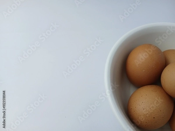 Fototapeta Group of brown raw eggs on a bowl, with copy space for text  isolated on white background